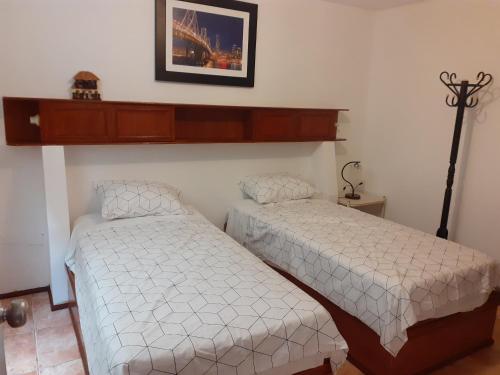 1 dormitorio con 2 camas y una foto en la pared en Inka Ayllu Hospedaje, en Lima