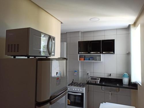 a kitchen with a refrigerator and a stove top oven at Lotus Apartamentos in Santarém
