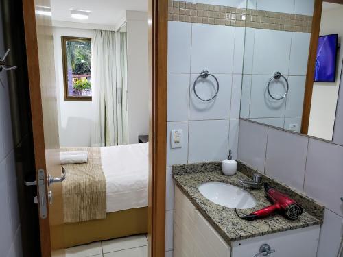 巴西利亚Life Resort às margens do lago的带水槽、床和镜子的浴室