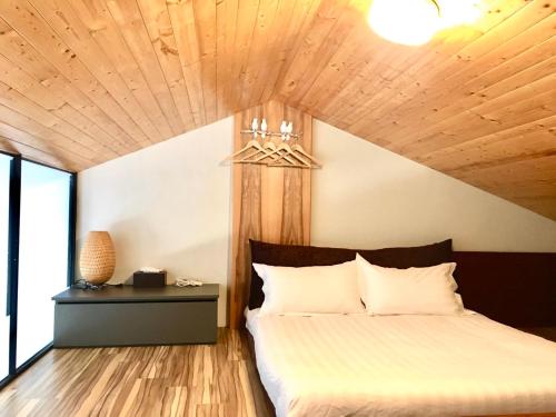 a bedroom with a bed with a wooden ceiling at Tainan Travel Inn in Tainan