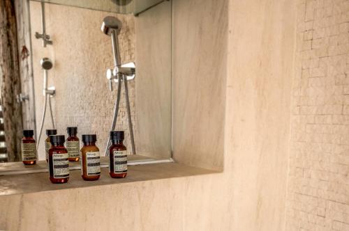 four bottles of alcohol sitting on a shelf in a shower at Song Saa Private Island in Song Saa Private Island