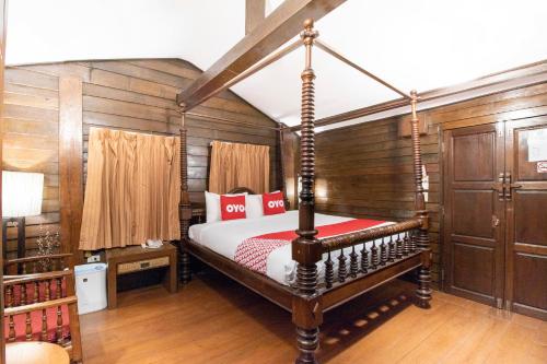 a bedroom with a canopy bed with red pillows at OYO 635 Sira Boutique Hotel in Chiang Mai