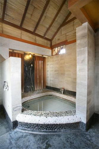 a bathroom with a jacuzzi tub in a building at Kampung Sumber Alam Garut in Garut