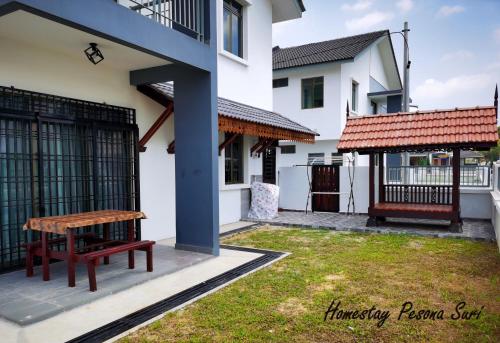 a picnic table in the courtyard of a house at Pesona Suri Homestay in Batu Pahat