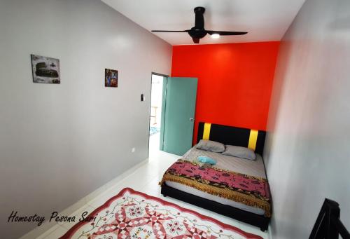 a bedroom with a bed and a red wall at Pesona Suri Homestay in Batu Pahat
