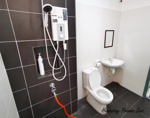 a bathroom with a shower with a toilet and a sink at Pesona Suri Homestay in Batu Pahat