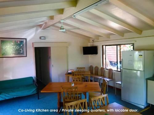 a dining room with a table and a refrigerator at Lilyponds Holiday Park in Mapleton