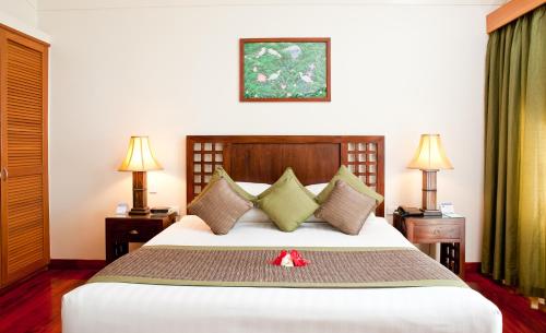 a bedroom with a large white bed with two lamps at The Naviti Resort in Korolevu