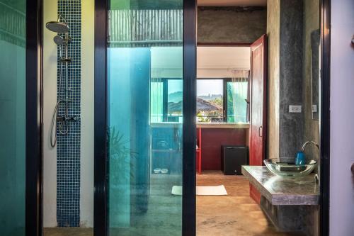 a bathroom with a glass shower and a sink at The Sanctuary Nam Ngum Beach Resort in Vang Vieng