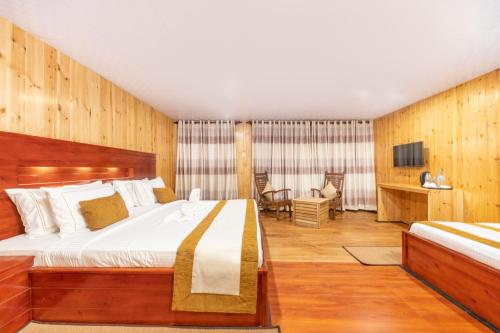 a bedroom with a large bed and a television at 3 Arch Resort Ella in Ella