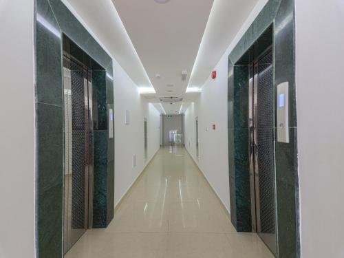 a hallway with green glass doors in a building at Diamond Star Hotel فندق النجمة الماسية in Seeb