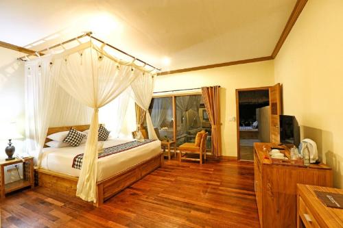 a bedroom with a bed with a canopy at Bhanuswari Villas Ubud in Ubud