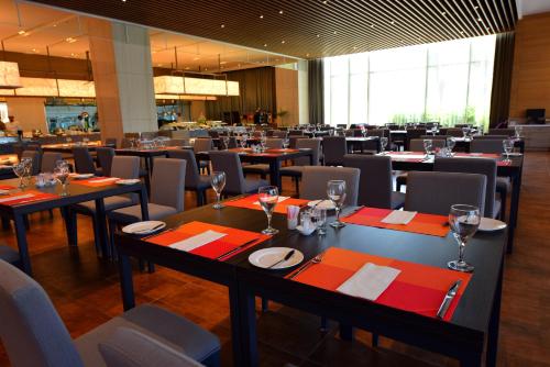 a dining room with tables and chairs with wine glasses at Grand Royal Hotel in Toufen