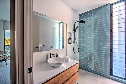 baño con lavabo y ducha con azulejos azules en Furneaux en Coles Bay