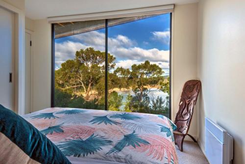 a bedroom with a bed and a large window at Furneaux in Coles Bay