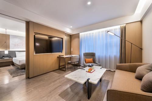 a hotel room with a couch and a bed at Novotel Xi'an The Bell Tower in Xi'an