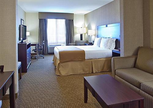 ein Hotelzimmer mit einem großen Bett und einem Sofa in der Unterkunft Norwood Inn & Suites Eagan St Paul & Mall of America in Eagan
