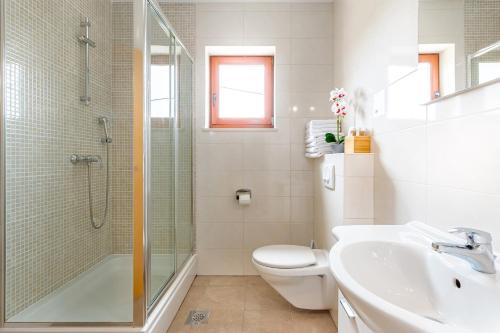 a bathroom with a shower toilet and a sink at Apartments Rina in Malinska