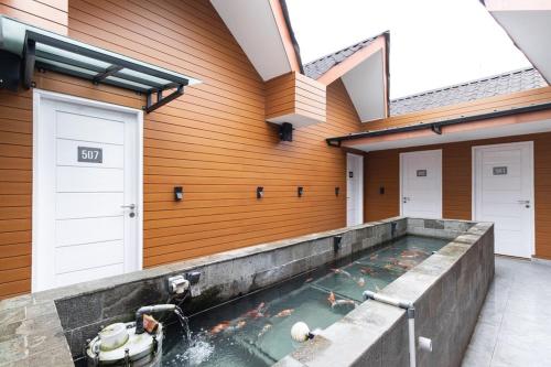 a swimming pool in a house with koi in the water at RedDoorz Premium near Centre Point Mall Medan in Medan