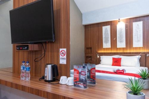 a room with a bed and a flat screen tv at RedDoorz Premium near Centre Point Mall Medan in Medan