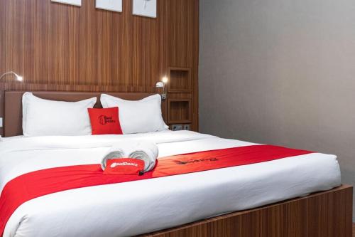 a bedroom with a large bed with a red blanket at RedDoorz Premium near Centre Point Mall Medan in Medan