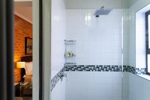 y baño con ducha y azulejos blancos y negros. en Twin Rivers Bed and Breakfast en Irene