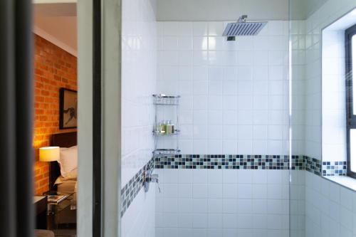 a bathroom with a shower with black and white tiles at Twin Rivers Bed and Breakfast in Irene