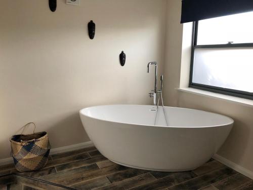 a white bath tub in a bathroom with a window at Lancaster in Boston