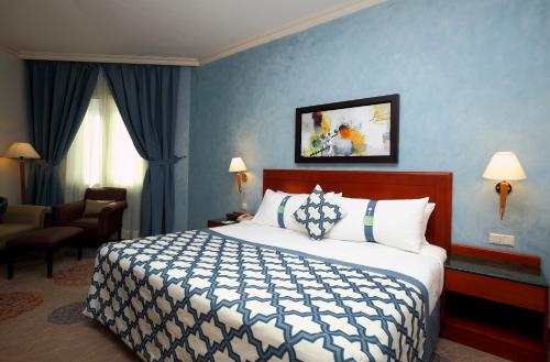 a hotel room with a bed with a blue wall at Holiday Inn Al Khobar by IHG in Al Khobar