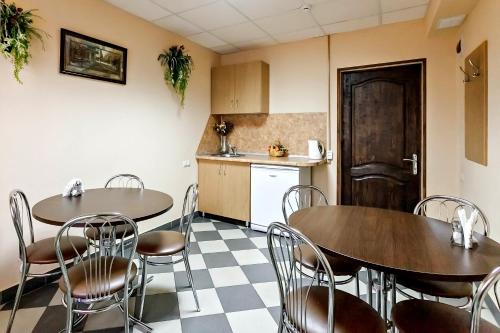 two tables and chairs in a room with a kitchen at Hotel A3 in Kislovodsk