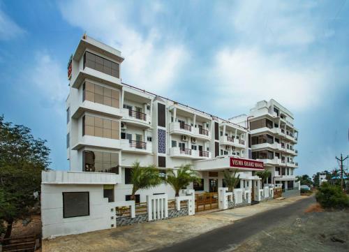 ein großes weißes Gebäude mit einem Schild drauf in der Unterkunft Hotel Viswa Grand in Kanyakumari