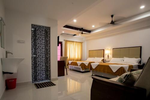 ein Hotelzimmer mit 2 Betten und einem Sofa in der Unterkunft Hotel Viswa Grand in Kanyakumari