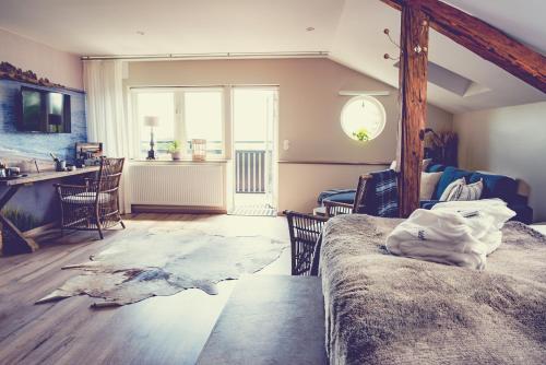 a room with a bed and a dining room with a table at Hotell Mossbylund in Abbekås