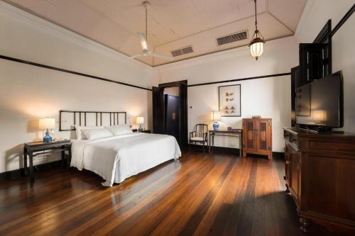 a bedroom with a bed and a flat screen tv at Cheong Fatt Tze - The Blue Mansion in George Town