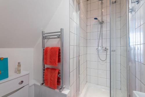 a bathroom with a shower with orange towels at Cherry Orchard in Shrewsbury