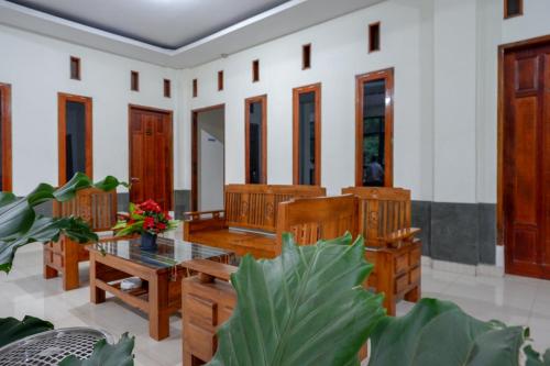 a room with wooden furniture and a glass table at Gosyen Efata Toraja Hotel in Makale