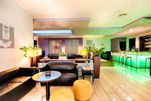 a hotel lobby with a couch and a bar at ACHAT Hotel Wiesbaden City in Wiesbaden