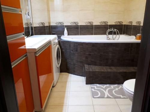 a bathroom with a tub and a sink and a toilet at Apartament Twoja Przystań in Giżycko