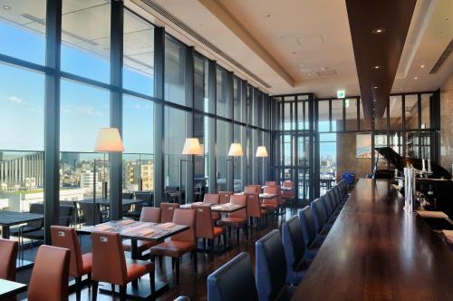 a restaurant with tables and chairs and large windows at The Gate Hotel Kaminarimon by Hulic in Tokyo