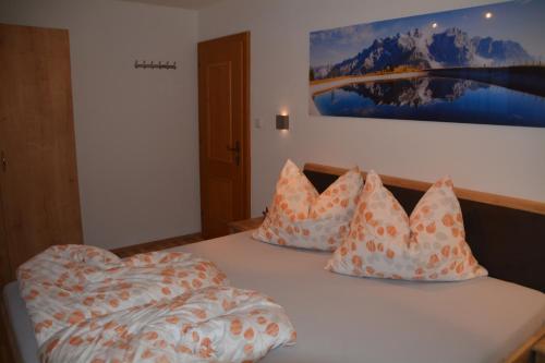 um quarto com uma cama com almofadas em Haus Höring em Dienten am Hochkönig