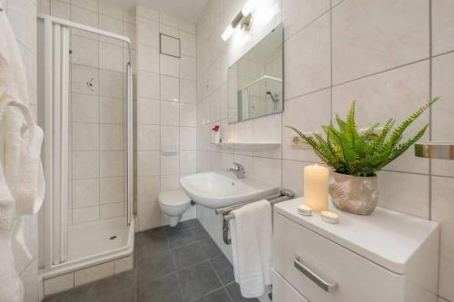 a white bathroom with a sink and a toilet at Kutterkoje in Zingst