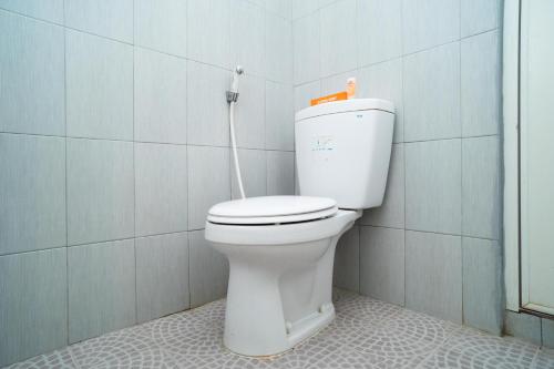 a bathroom with a white toilet in a room at Sitiinggil Syariah RedPartner in Tegal