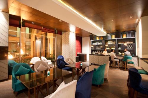 a restaurant with green chairs and a bar at Hyatt Regency Amritsar Hotel & Spa in Amritsar