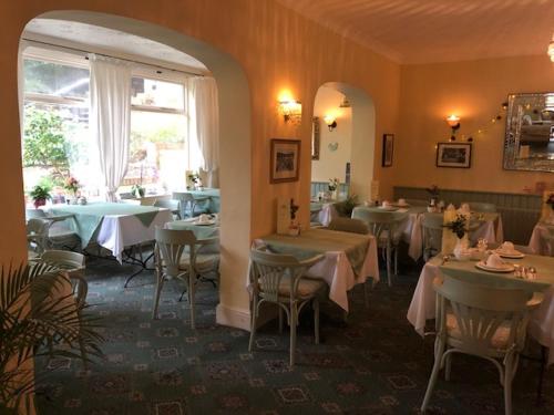 um restaurante com mesas e cadeiras e uma janela em Bedford Lodge em Shanklin