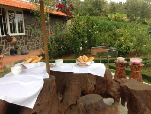a table in a tree stump with bread on it at Dalat Terrasse Des Roses Villa in Da Lat