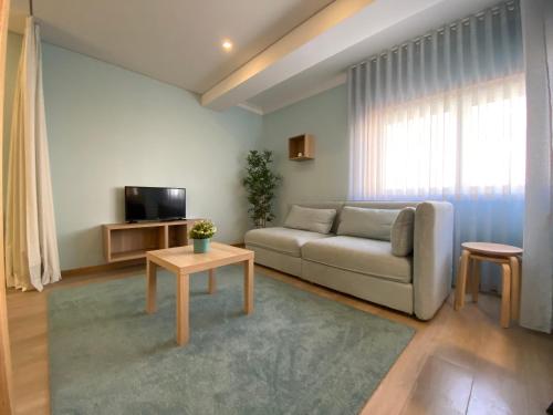 a living room with a couch and a tv at Casa do Recife, Natureza e Conforto in Viana do Castelo