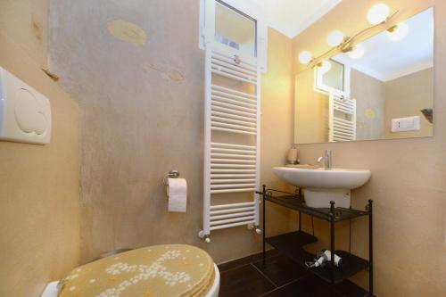 a bathroom with a sink and a toilet and a mirror at La vita è bella - Noli in Noli
