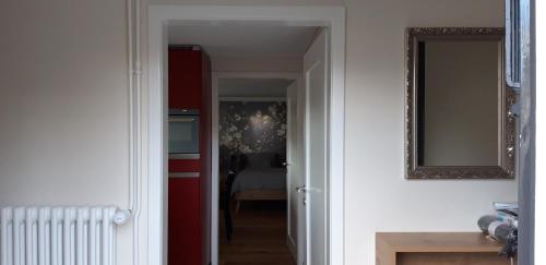 a hallway with a mirror and a room with a bed at Appartement Säntisblüte in Rehetobel