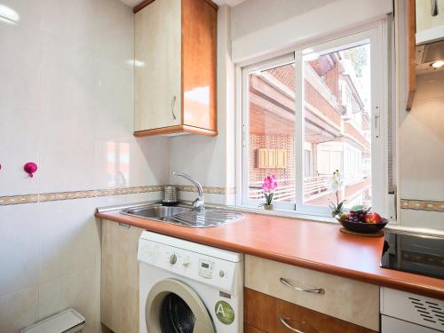 cocina con lavadora y ventana en My City Home- Bright apartment in great location, en Madrid
