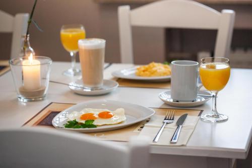 a table with two eggs and two glasses of orange juice at Hotel Omega in Moers